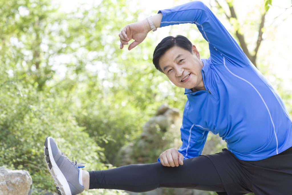 Happy mature Chinese man exercising in park